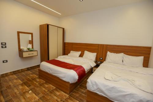 a hotel room with two beds and a mirror at The SACRED ANGLE pyramids view in Cairo