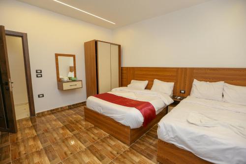 开罗The SACRED ANGLE pyramids view的有两张床和一面镜子的酒店房间