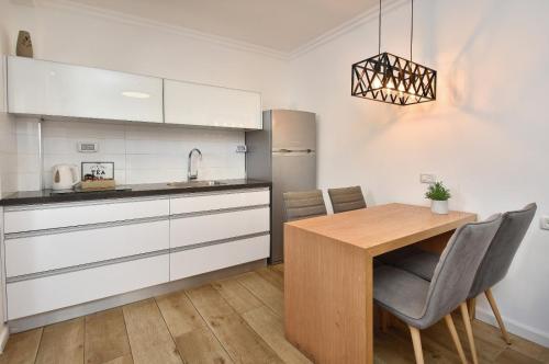 a kitchen with a wooden table and a kitchen with white cabinets at sea of Galilee 612 in Tiberias