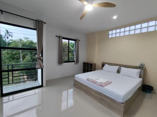 a bedroom with a bed and a large window at Krabi Rooms - Appartment 4 in Krabi town