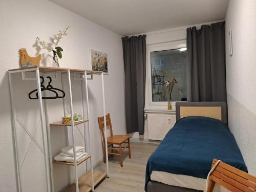 Un pequeño dormitorio con una cama azul y una ventana en BurgK59, 3 BR, 4 Beds, TV, Kitchen and Bath, en Muldenstein