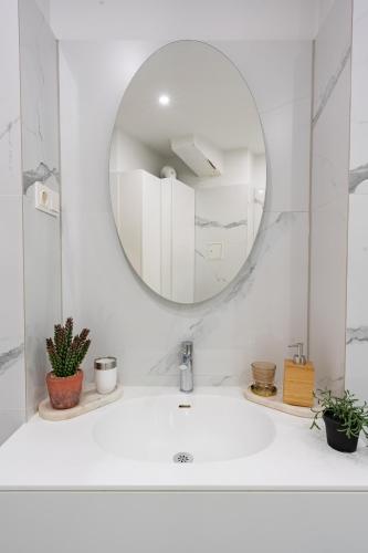 a white bathroom with a sink and a mirror at Vienna Deluxe Residences - Schönbrunn in Vienna