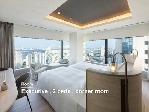 a bedroom with a bed and a view of the city at Mitsui Garden Hotel Yokohama Minatomirai Premier in Yokohama