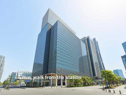 a tall building with a sign walk from the station at Mitsui Garden Hotel Yokohama Minatomirai Premier in Yokohama