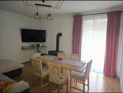 a living room with a table with chairs and a fireplace at Kuća Lidija in Rab