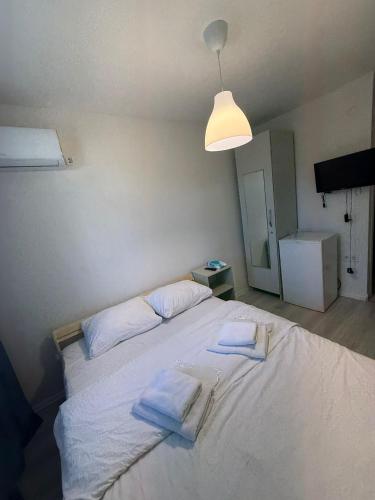 Un dormitorio con una gran cama blanca con toallas. en Şişli Suites - Room44, en Estambul