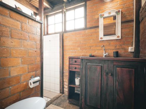 a bathroom with a sink and a brick wall at Casa Pindorama - Chalé Opy in Paraty