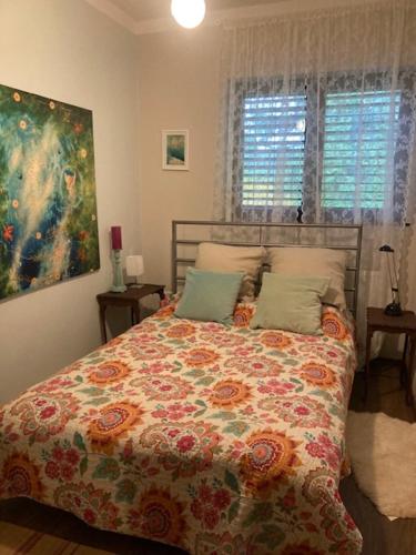 Un dormitorio con una cama con un edredón floral. en Wéber Villa, en Gyenesdiás