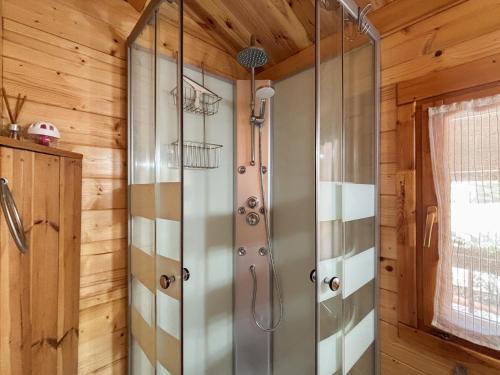 a shower in a bathroom with wooden walls at Chale dos Sobreiros in Bicas