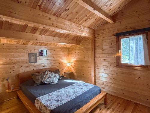 a bedroom with a bed in a log cabin at Chale dos Sobreiros in Bicas