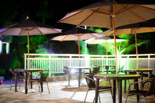 a group of tables and chairs with umbrellas at Pousada Chale da Montanha in Petrópolis