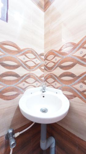 a bathroom with a white sink in a room at Varun Residency New in Coimbatore