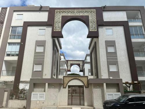 a building with an arch in front of it at Appartement Neuf au Bord de la Mer - Hammamet Sud Zone Touristique in Hammamet