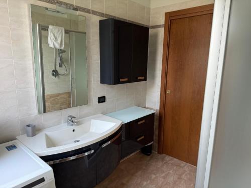 un baño con lavabo y espejo en 5 min to Equieffe & Private Parking - Teo House, en Gorla Maggiore