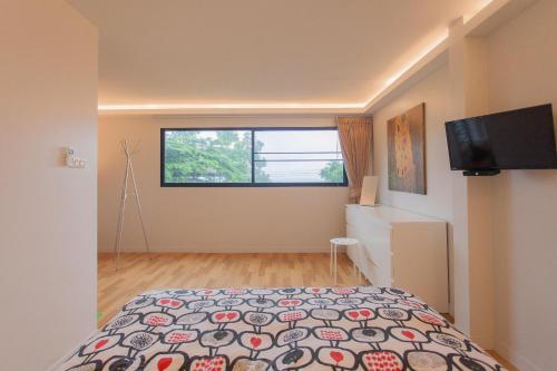 a bedroom with a bed and a flat screen tv at Bamboo Garden House in Laem Sing