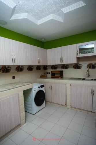 a kitchen with a washer and dryer in a room at Residence Cabral in Guediawaye