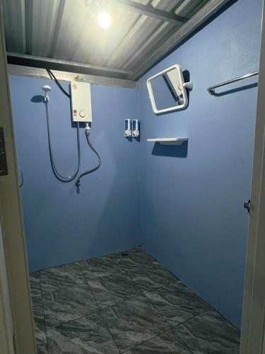 a bathroom with a blue wall with a shower at Khaosok Campsite in Khao Sok National Park