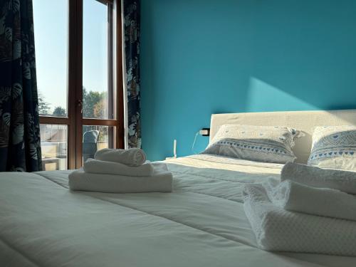 1 cama con toallas y ventana en 5 min to Equieffe & Private Parking - Teo House, en Gorla Maggiore