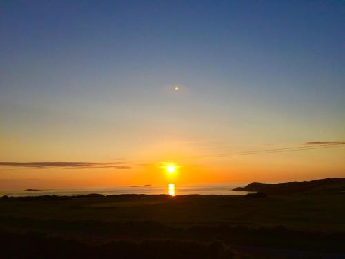 a sunset over the ocean with the sun in the sky at Craig-Y-Mor Suites With Sea Views Whitesands Bay St Davids in St. Davids