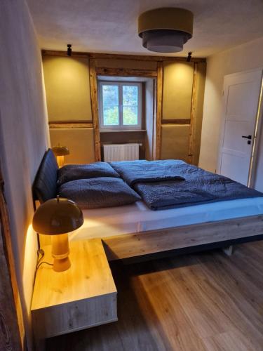 Un dormitorio con una cama grande y una mesa de madera. en Rebhaus Adams, en Moselkern