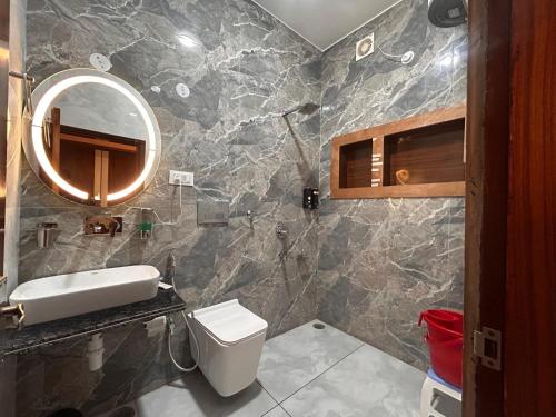 a bathroom with a sink and a toilet and a mirror at The Satluj Vista in Bilāspur