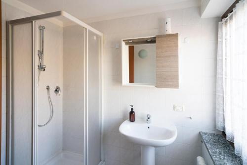 a white bathroom with a sink and a shower at Stars Apartments Gressan in Cerise