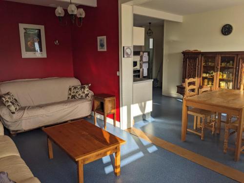 een woonkamer met een bank en een tafel bij Maison centre de Barfleur in Barfleur