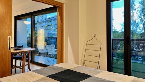 a bedroom with a bed and a table and a window at Parque Nações - premium location and river view in Lisbon