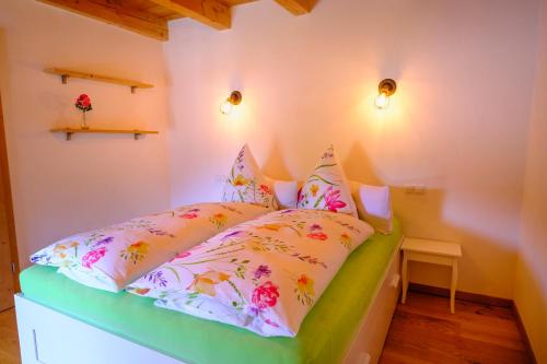 a small bedroom with a bed with flowers on it at Zum Friedl in Wackersberg