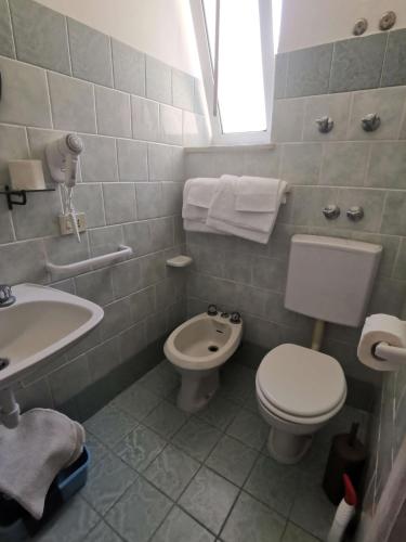 a white bathroom with a toilet and a sink at Villa Olivia Residence Ischia - nel Verde con Piscine e Vista Mare in Forio d'Ischia