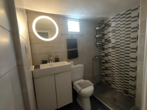 um banheiro com uma pia, um vaso sanitário e um espelho em Sea Side Studio with Balcony and Sea View em Ayía Kiriakí