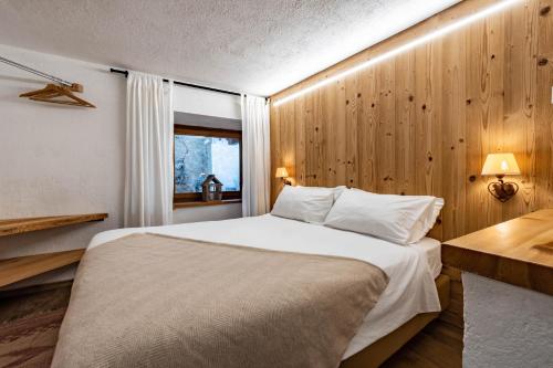 ein Schlafzimmer mit großem Bett und Fenster in der Unterkunft Lo Péyo - Le Four des Alpes in Rhemes-Saint-Georges