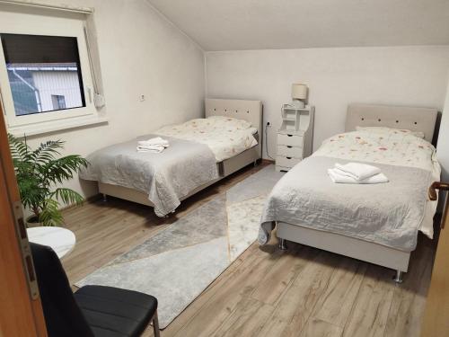 a bedroom with two beds and a window at Apartmani LIDER Visoko in Visoko
