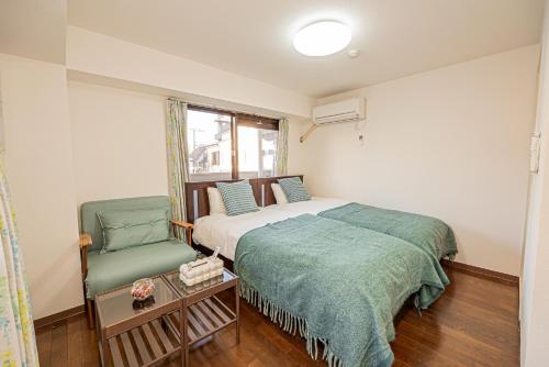 a bedroom with a bed and a green chair at sakura 201 in Tokyo