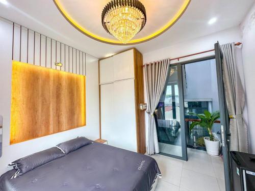 a bedroom with a bed and a chandelier at Lâm Phong Hotel in Tây Ninh