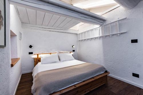 ein Schlafzimmer mit einem großen Bett in einem weißen Raum in der Unterkunft Petit Câlin - Le Four des Alpes in Rhemes-Saint-Georges