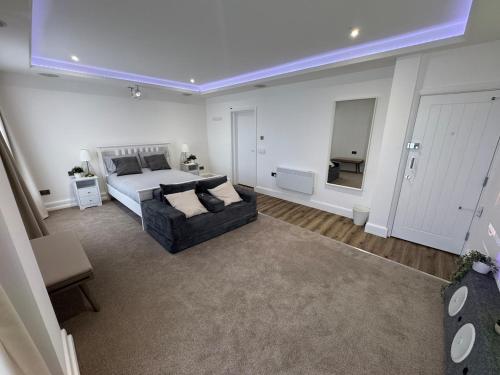 a large bedroom with a bed and a couch at Cinema room apartment 2 in Basildon