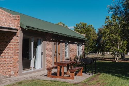 a brick building with a picnic table and a grill at Welverdiend - Unit 1 in Bloemfontein