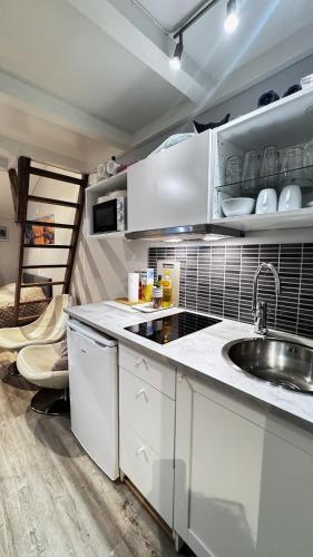 a kitchen with white cabinets and a sink at Sleep with the stars in Oslo