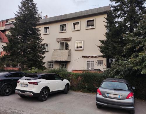 two cars parked in a parking lot in front of a house at La casa dei mici in Arezzo