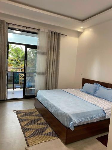 a bedroom with a bed and a large window at maman home apartment in Gisenyi