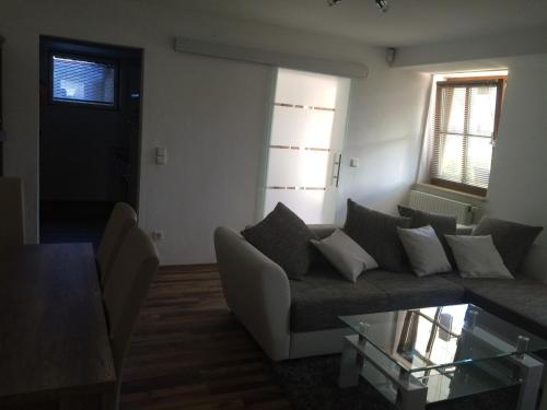 uma sala de estar com um sofá e uma mesa de vidro em L&L Lodge Günding em Günding