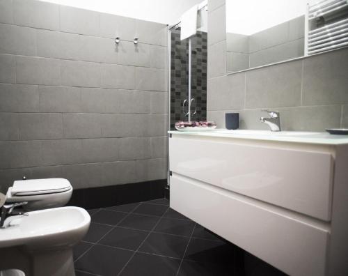 uma casa de banho branca com um lavatório e um WC em Costantino Secondo Guest House em Roma