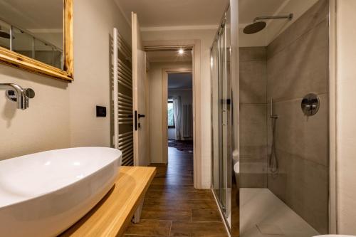 ein Badezimmer mit einem weißen Waschbecken und einer Dusche in der Unterkunft Lo Micho - Le Four des Alpes in Rhemes-Saint-Georges