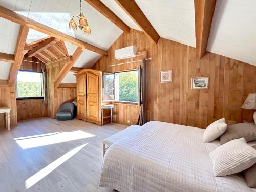 a bedroom with a bed in a room with wooden walls at Chalet au bord d'un lac privé in Saint-Estèphe