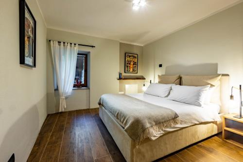 ein Schlafzimmer mit großem Bett und Fenster in der Unterkunft La Tsambra-Le Four des Alpes in Rhemes-Saint-Georges