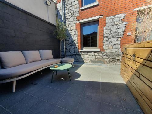 een bank op een patio naast een gebouw bij Le Mas d 'Ecaussinnes in Écaussinnes-dʼEnghien