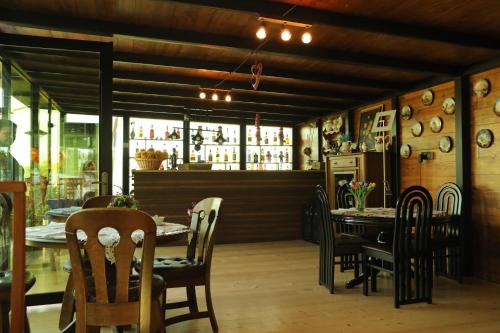 a dining room with a table and chairs and a bar at Panorama Sormoni in Dzhimastaro