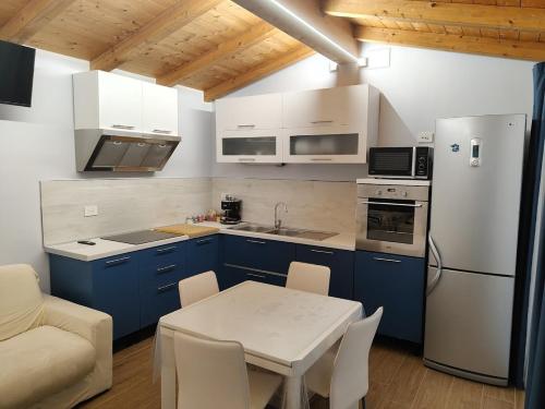 a kitchen with blue cabinets and a white refrigerator at Iris Cottage in Anzola dell'Emilia