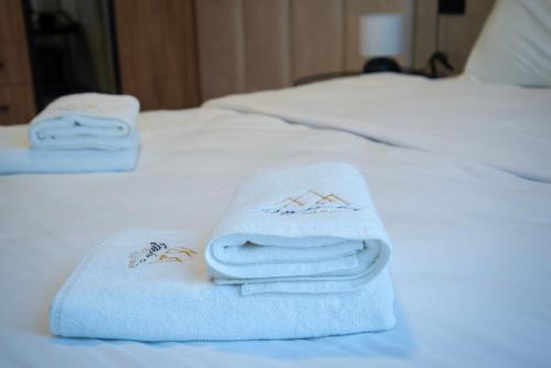 two towels sitting on top of a bed at Apartmani Aurora Zlatibor in Zlatibor
